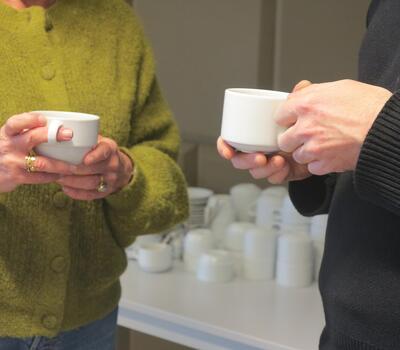 2 personnes tiennent des tasses de café