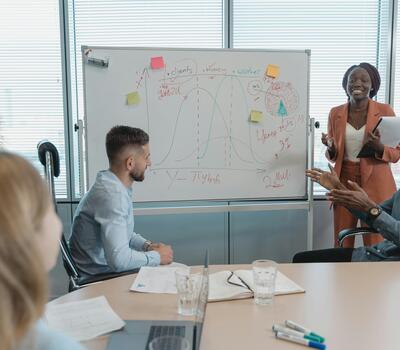 Des personnes échangent des idées autour d'un tableau blanc