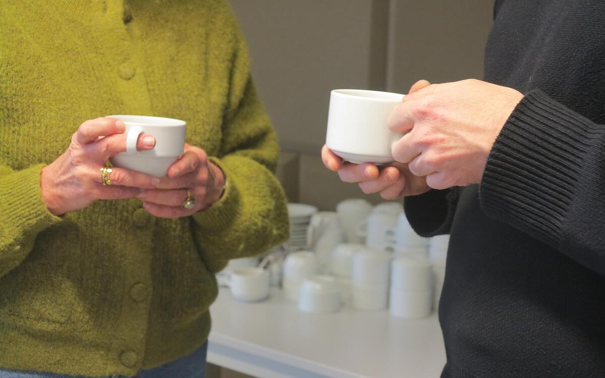 2 personnes tiennent des tasses de café